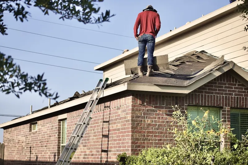 Professional roofer working on a residential roof in North Acton